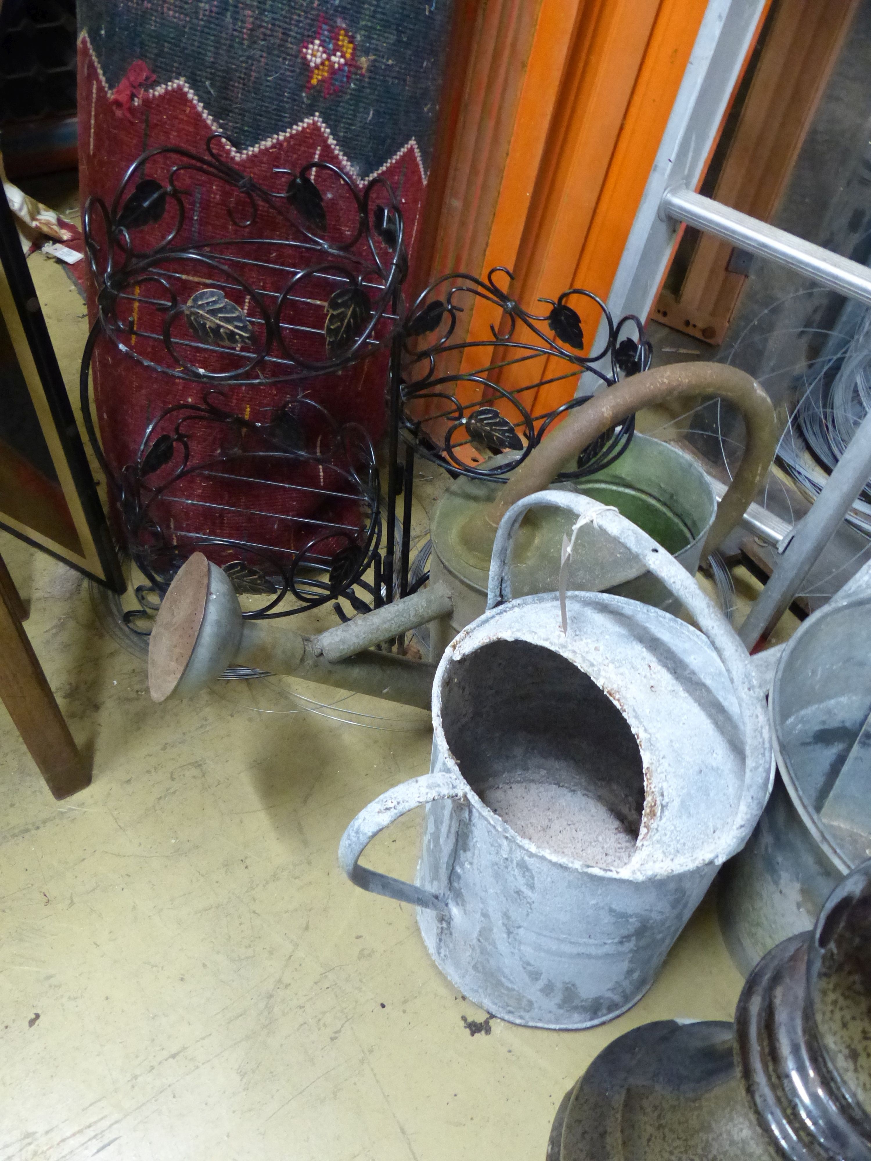 Assorted galvanized watering cans and assorted other metalware.